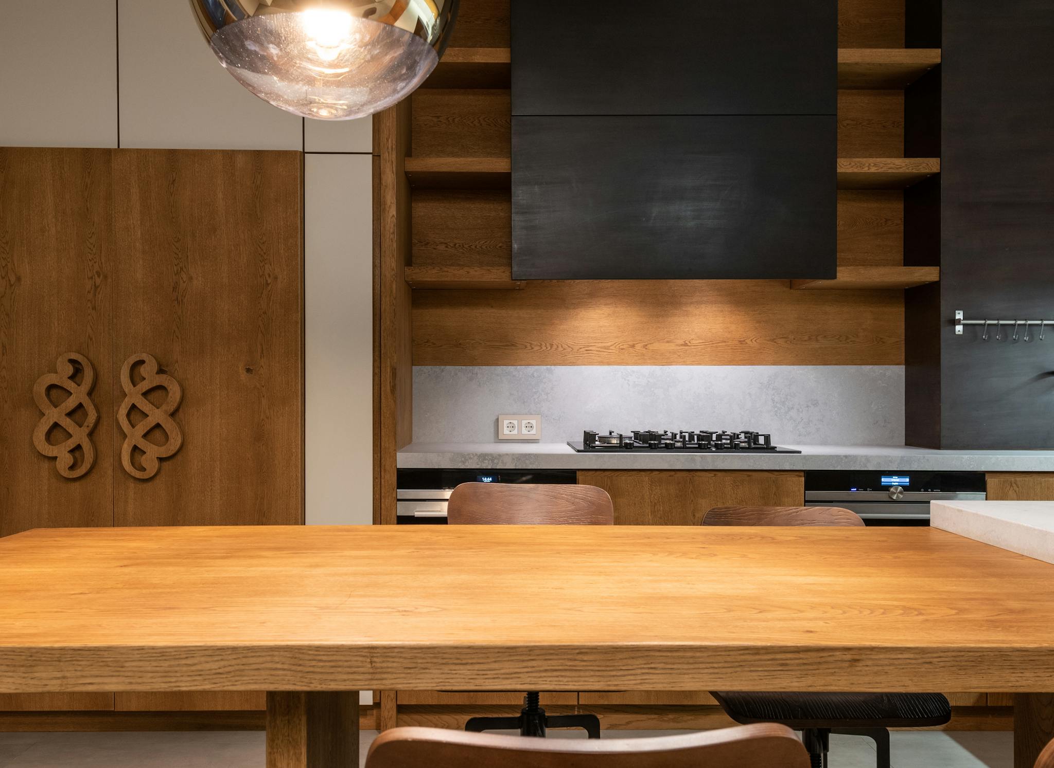 Stylish kitchen with wooden furniture, gas stove, and minimalistic decor.